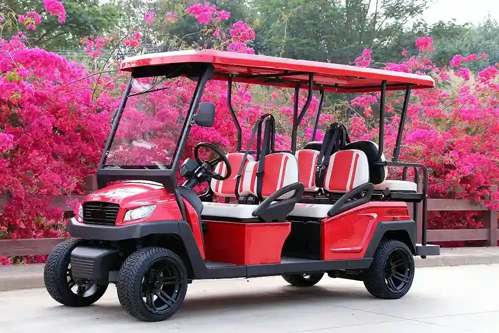 Bright red six-passenger Bintelli golf cart by a bougainvillea-lined property